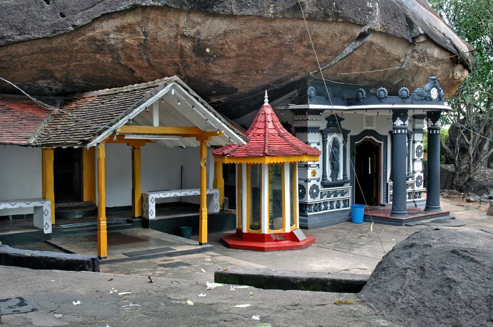 White stupa at Sankhapala Raja Maha Viharaya beside a rock cliff